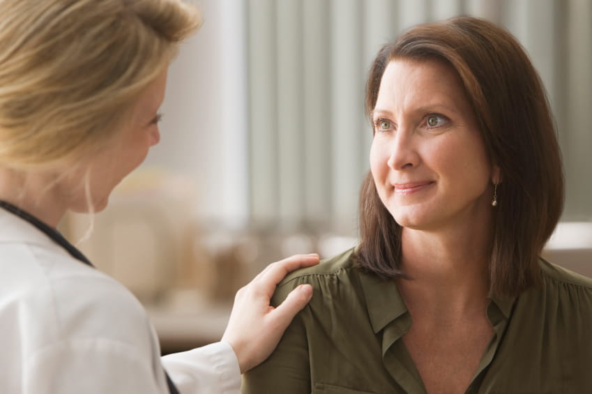 doctor touching female patient's shoulder