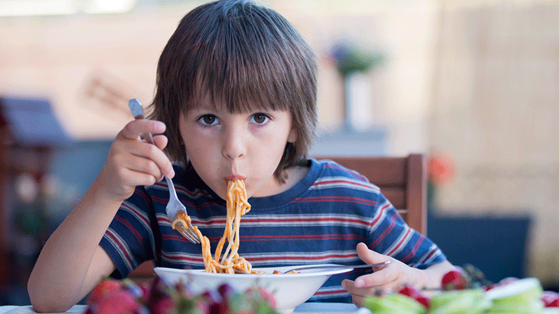 Boy eating spaghetti