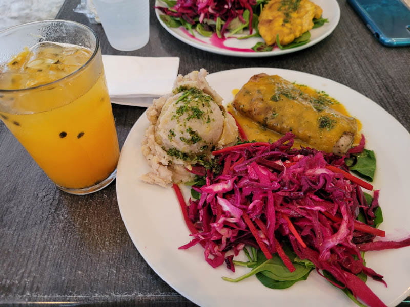 En uno de sus cafés favoritos en San Juan, Puerto Rico, Josiemer Mattei disfruta de comidas tradicionales: jugo de maracuyá natural recién exprimido; majado de vianda; ensalada de repollo morado, zanahoria y remolacha; y filete de salmón en salsa acerola. (Foto cortesía de Josiemer Mattei)