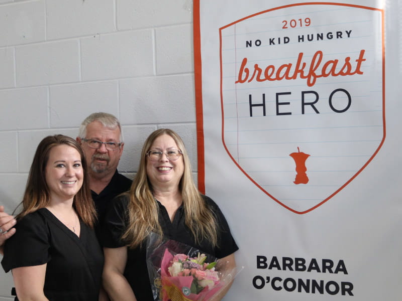 Barbara O'Connor (right) with her husband, John, and daughter Christine after O'Connor won an award in 2019 for her nutrition efforts at Morrow Middle School in Georgia. (Photo courtesy of Barbara O'Connor)