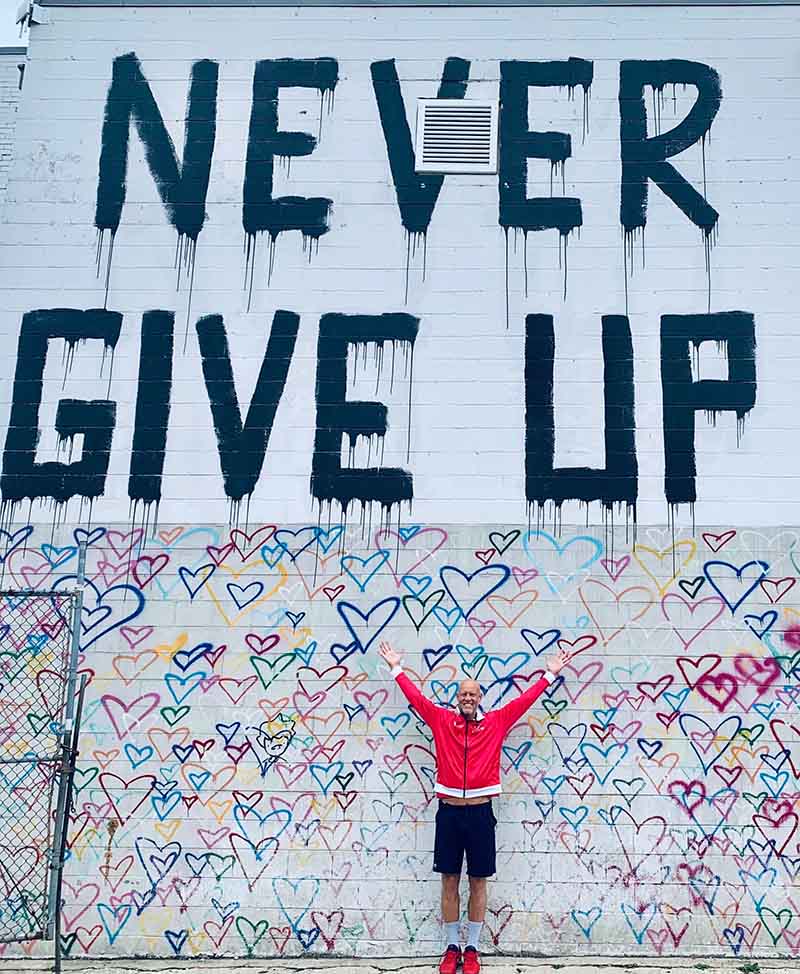 Murphy Jensen in front of a painted building in Washington D.C. with a fitting message: 