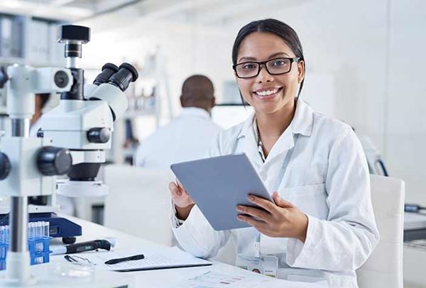 female medical researcher in lab holding clipboard