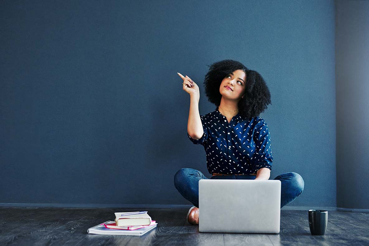 Woman using a laptop and sitting on the floor