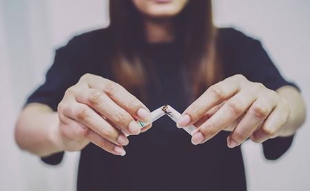 woman quits smoking woman breaking a cigarette in half