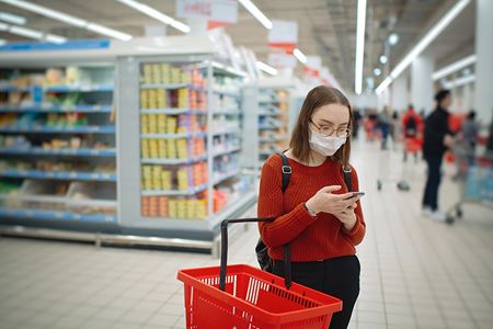 woman shopper reads Heart-Check certified product list while shopping woman shopper reads Heart-Check certified product list while shopping