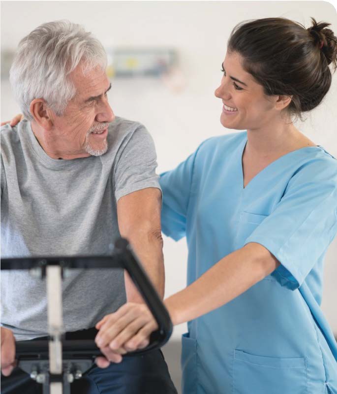 man smiling at nurse while on a cycle machine in cardiac rehab