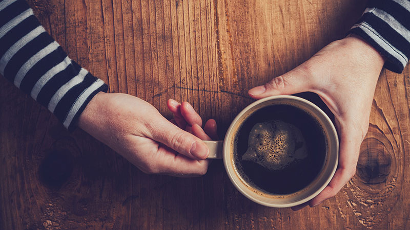 hands holding cup of coffee