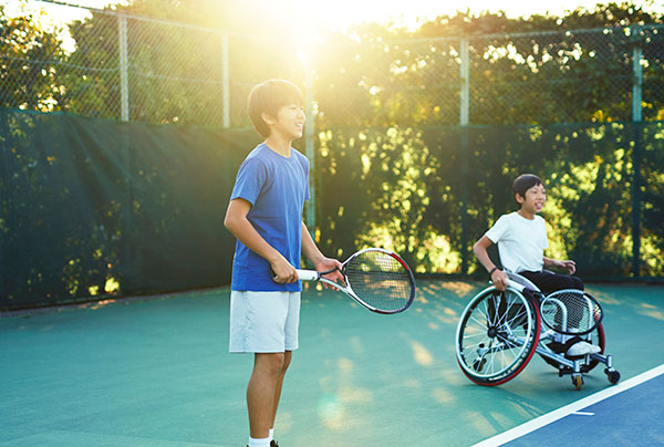 Teenager in wheelchair playing tennis Teenager in wheelchair playing tennis