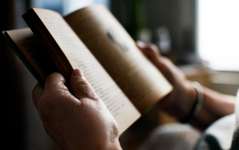 Hands holding book.