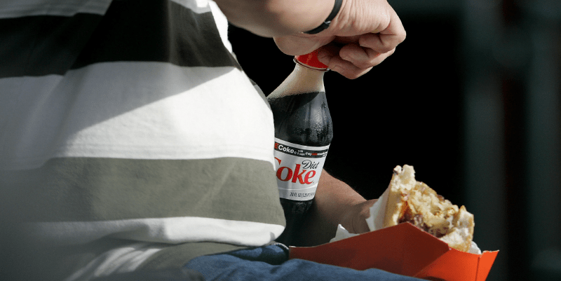 man holding soda and burger