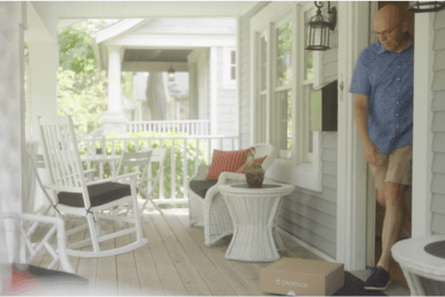 Man retrieving package by front door