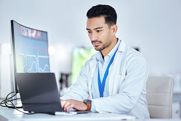 a doctor using a laptop in his office