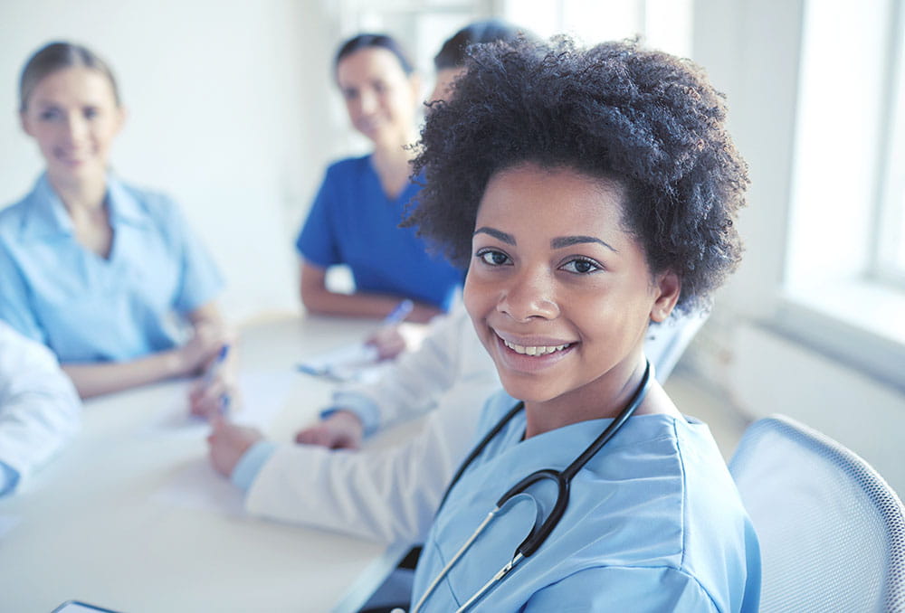 smiling doctor with group of medical professionals