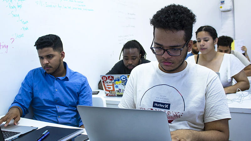 A classroom of diverse students working on laptop computers at The Knowledge House A classroom of diverse students working on laptop computers at The Knowledge House